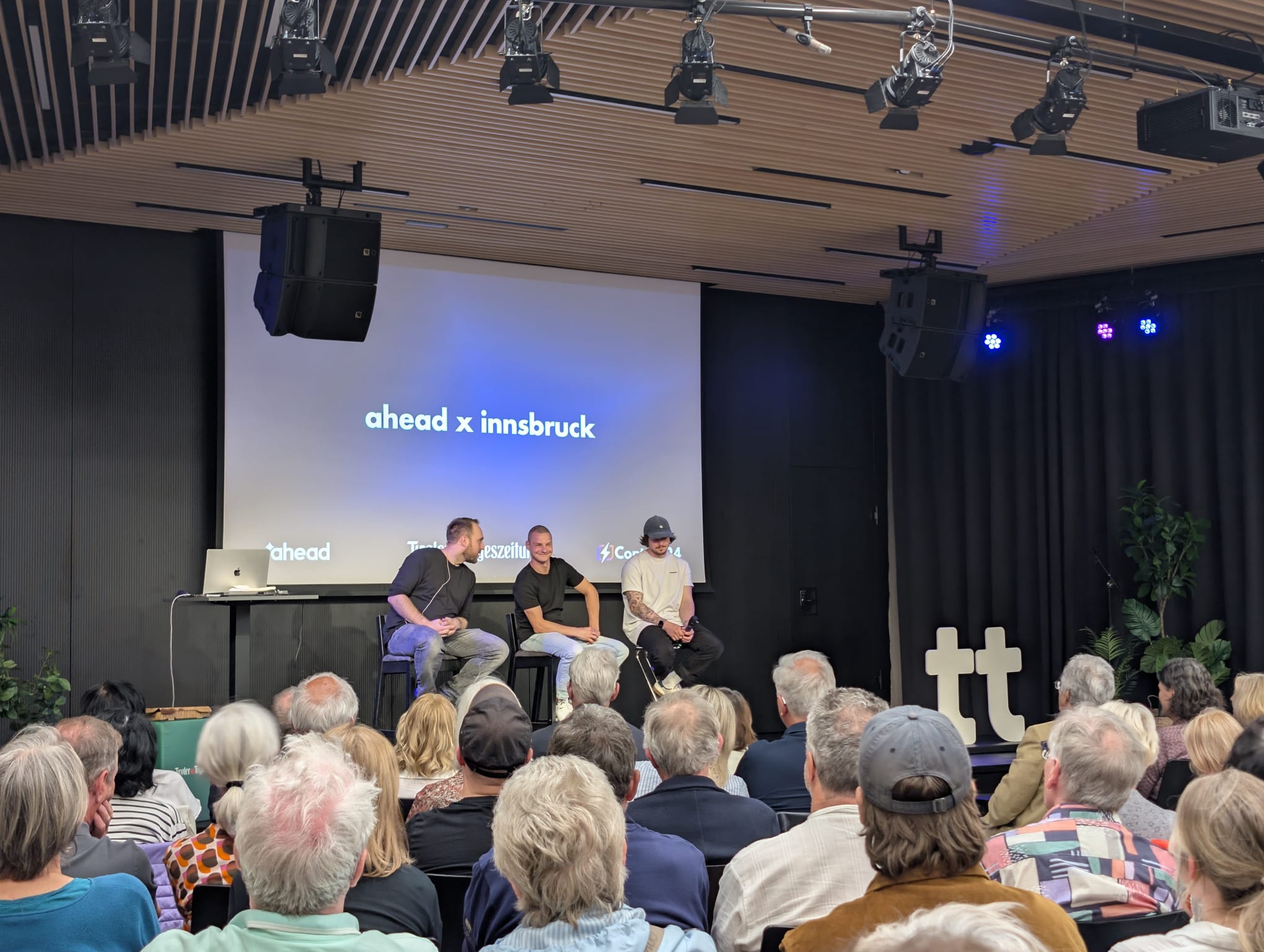 ahead x innsbruck — voller Saal, viele Senior:innen, drei Speaker auf der Bühne